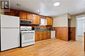 Niagara Falls (Cherrywood) apartment for rent - A kitchen with wooden cabinets and white appliances.