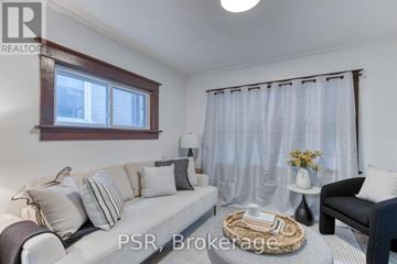 Kitchener apartment for rent - A living room with a sofa, a chair, and a table with a vase of flowers on it.