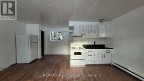 Wasaga Beach multi-family for rent - A kitchen with white appliances and cabinets is on the market.