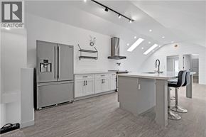 Brantford apartment for rent - A modern kitchen with a refrigerator, stove, and bar stools.