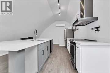 Brantford apartment for rent - A modern kitchen with white cabinets and a stainless steel range hood.