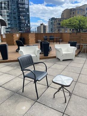 Toronto (Mount Pleasant West) condo for rent - A patio with a black chair, a white chair, and a white ottoman.