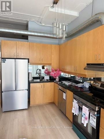 Toronto (Mount Pleasant West) condo for rent - A kitchen with wooden cabinets and a stainless steel refrigerator.