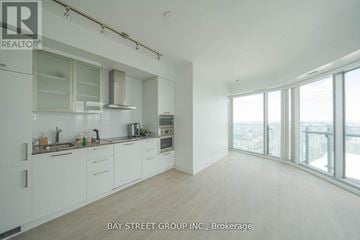 Toronto (Waterfront Communities) condo for rent - A spacious kitchen with white cabinets and a view of the city.