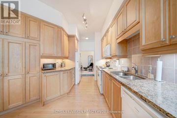Toronto (Bayview Village) condo for rent - A kitchen with wooden cabinets and a white countertop.