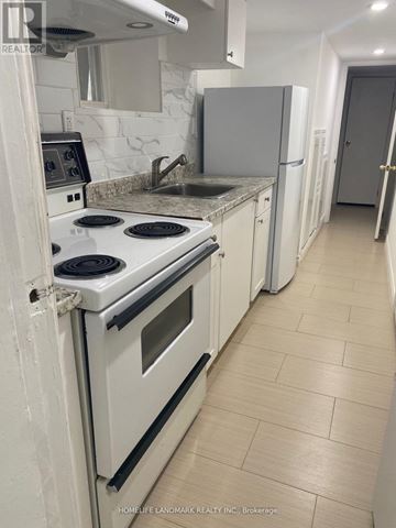 Toronto (Oakwood Village) apartment for rent - A kitchen with a white stove top oven and white cabinets.