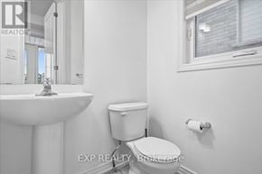 Cobourg apartment for rent - A white bathroom with a toilet, sink, and window.