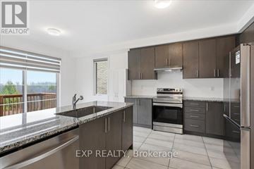 Cobourg apartment for rent - A modern kitchen with dark brown cabinets and stainless steel appliances.
