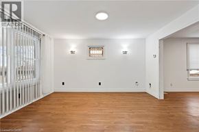 Niagara Falls apartment for rent - A room with wooden floors and white walls, with a window and a door visible.