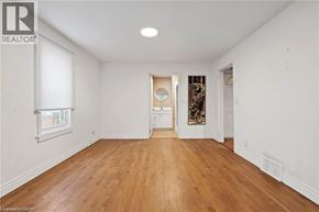 Niagara Falls apartment for rent - A large empty room with wooden floors and white walls.