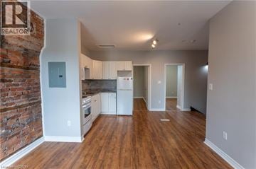 Hamilton townhouse for rent - A kitchen with white cabinets and a brick wall.