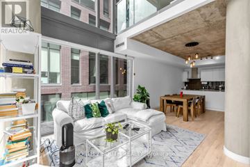 Toronto (Waterfront Communities) condo for rent - A living room with a white couch and a glass coffee table.