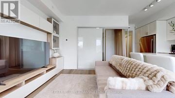 Toronto (O'connor-Parkview) townhouse for rent - A modern living room with a large couch and a flat screen TV.