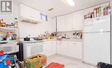 Mississauga (Hurontario) apartment for rent - A kitchen with white appliances and cabinets is cluttered with items.