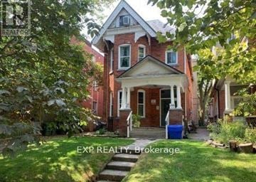 Toronto (South Parkdale) multi-family for rent - A house with a red door and a sign that says EXP REALTY Brokerage.