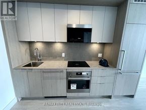 Toronto (Bayview Village) condo for rent - A modern kitchen with a stainless steel oven and a microwave above the stove.