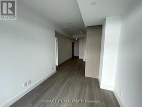 Toronto (Bayview Village) condo for rent - A spacious room with wooden flooring and white walls.
