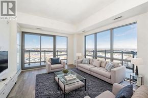Clarington (Bowmanville) condo for rent - A living room with a couch, a coffee table, and a large window overlooking the city.
