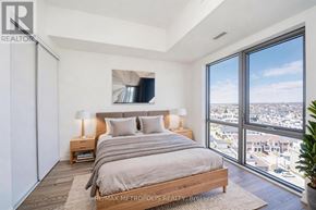 Clarington (Bowmanville) condo for rent - A bedroom with a large bed and a view of the city.