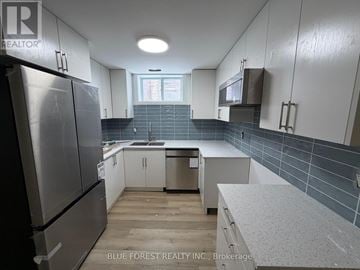 London South (South J) apartment for rent - A kitchen with white cabinets and a refrigerator.