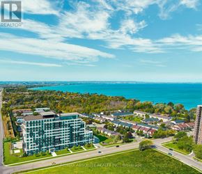 Hamilton (Lakeshore) condo for rent - A real estate company's brochure image of a residential area with a large building in the foreground and a body of water in the background.