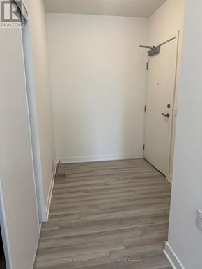 Clarington (Bowmanville) condo for rent - A hallway with a wooden floor and a white door.