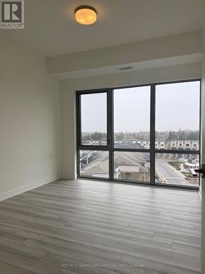 Clarington (Bowmanville) condo for rent - A room with a large window overlooking a residential area.