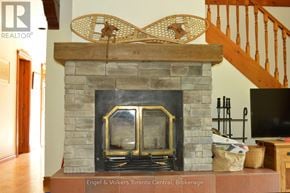 Blue Mountains apartment for rent - A fireplace with a stone mantle and a fire burning inside.
