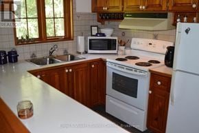 Blue Mountains apartment for rent - A kitchen with a white stove and a white refrigerator.
