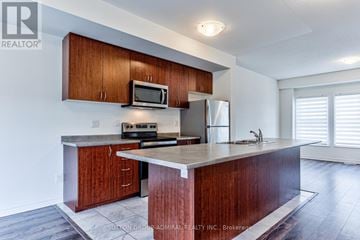 Wasaga Beach apartment for rent - A kitchen with wooden cabinets and a granite countertop.