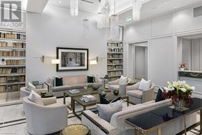 Toronto (Annex) condo for rent - A living room with a large painting on the wall and a bookshelf filled with books.
