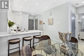 Toronto (Annex) condo for rent - A modern kitchen with a bar area and a glass table.
