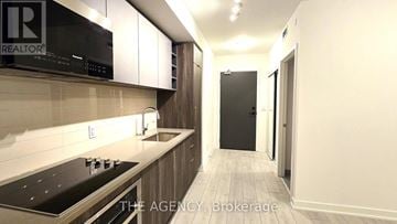 Toronto (Agincourt South-Malvern West) condo for rent - A kitchen with a black microwave and stove top oven.