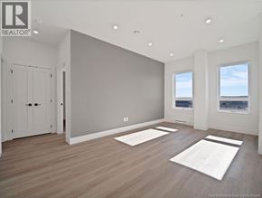 Moncton apartment for rent - A spacious room with wooden floors and two windows.