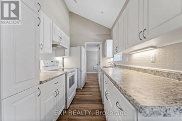 Stirling-Rawdon (Stirling Ward) triplex for rent - A kitchen with white cabinets and marble countertops.