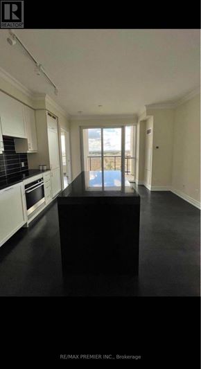 Vaughan (Concord) condo for rent - A black table in a white kitchen with a view of the balcony.