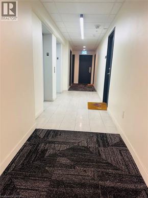 Waterloo condo for rent - A hallway with a rug on the floor and doors on either side.