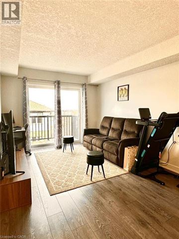 Kitchener condo for rent - A living room with a brown couch and a television.