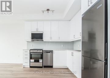 Oakville (Wm Westmount) condo for rent - A modern kitchen with white cabinets and stainless steel appliances.
