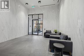 Ottawa condo for rent - A waiting area with a grey sofa and a black stool.