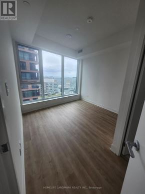 Markham (Unionville) condo for rent - A room with wooden flooring and a view of the city through a large window.