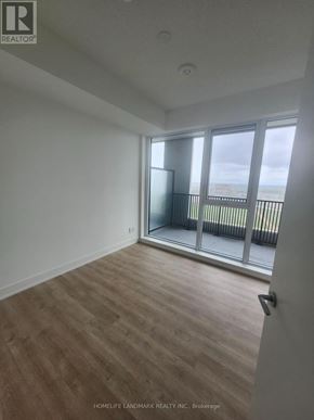 Markham (Unionville) condo for rent - A room with wooden flooring and a sliding glass door leading to a balcony.