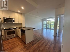 Burlington condo for rent - A kitchen with wooden floors and white cabinets.
