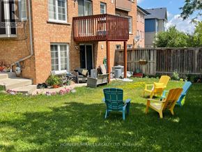 Mississauga (Central Erin Mills) duplex for rent - A backyard with a patio, a fire pit, and a yellow chair.