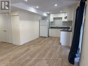 Mississauga (Central Erin Mills) duplex for rent - A well-lit kitchen with white cabinets and a wooden floor.