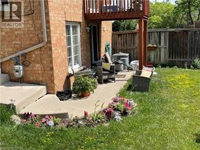 Mississauga apartment for rent - A small patio with a table and chairs is surrounded by a wooden fence.