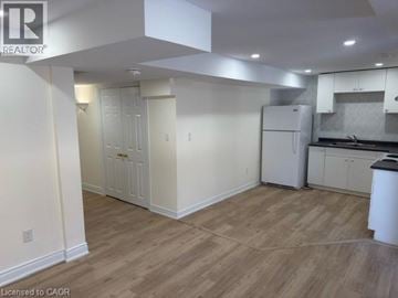Mississauga apartment for rent - A kitchen area with white cabinets and a refrigerator.