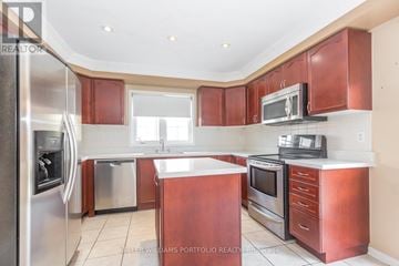 Brampton (Fletcher's Meadow) apartment for rent - A kitchen with red cabinets and stainless steel appliances.