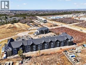 Riverview apartment for rent - A large building with a grey roof is surrounded by a parking lot.