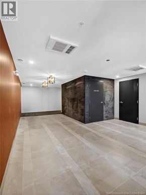 Riverview apartment for rent - A hallway with a tiled floor and a wall with a brown and black design.